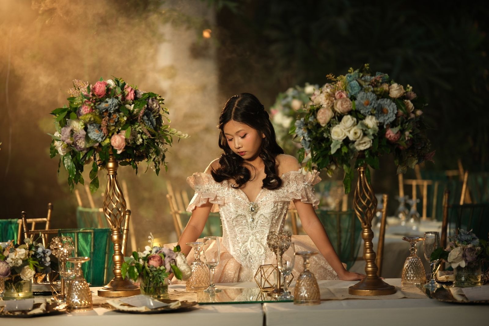 Woman in a formal gown beside an elegant floral dinner setting