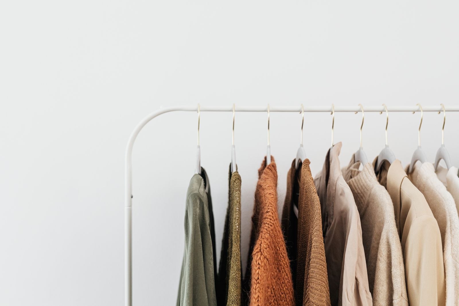 Neutral-colored clothes arranged on a clothing rack