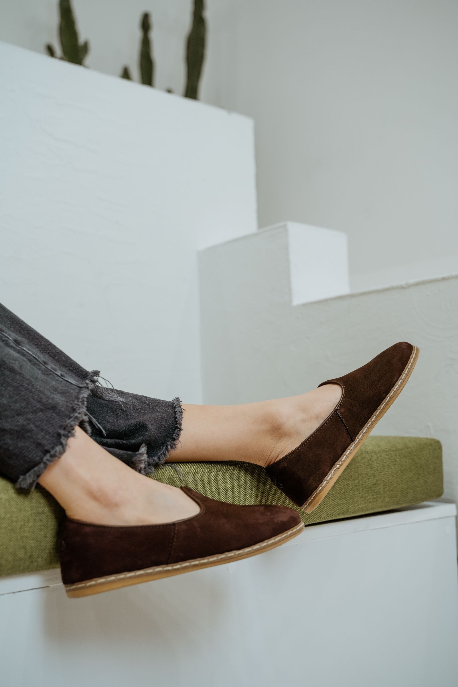 Brown loafers worn with frayed blue jeans