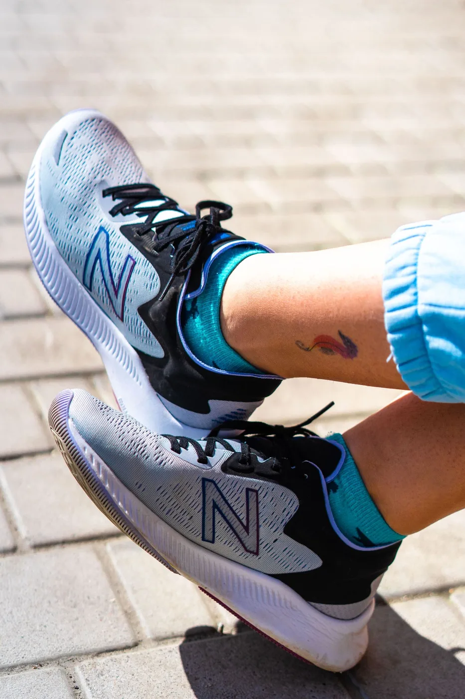 Grey sneakers and bright socks worn outdoors.