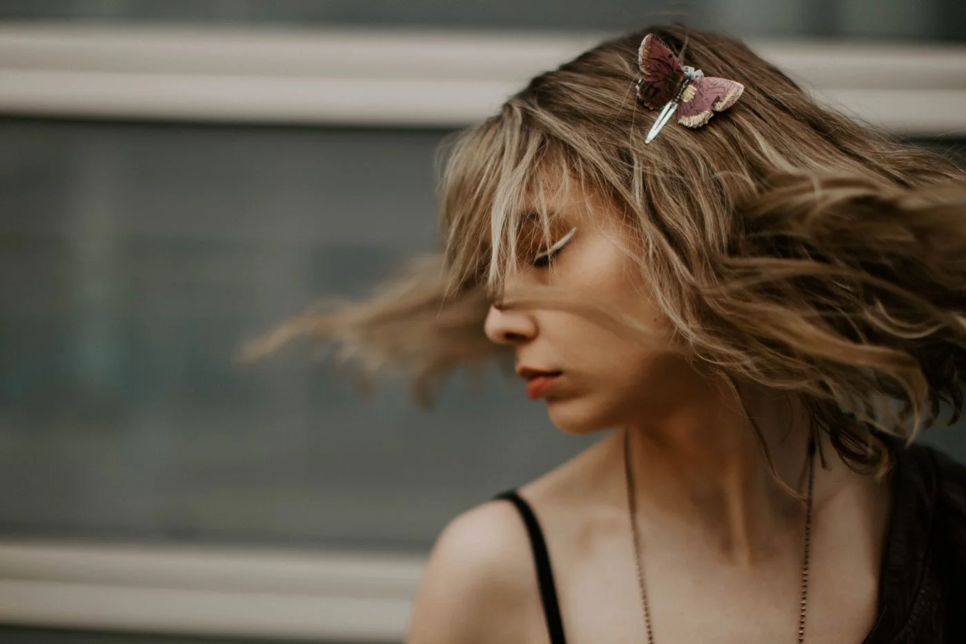 A woman with hair held partly back by a decorative butterfly clip.