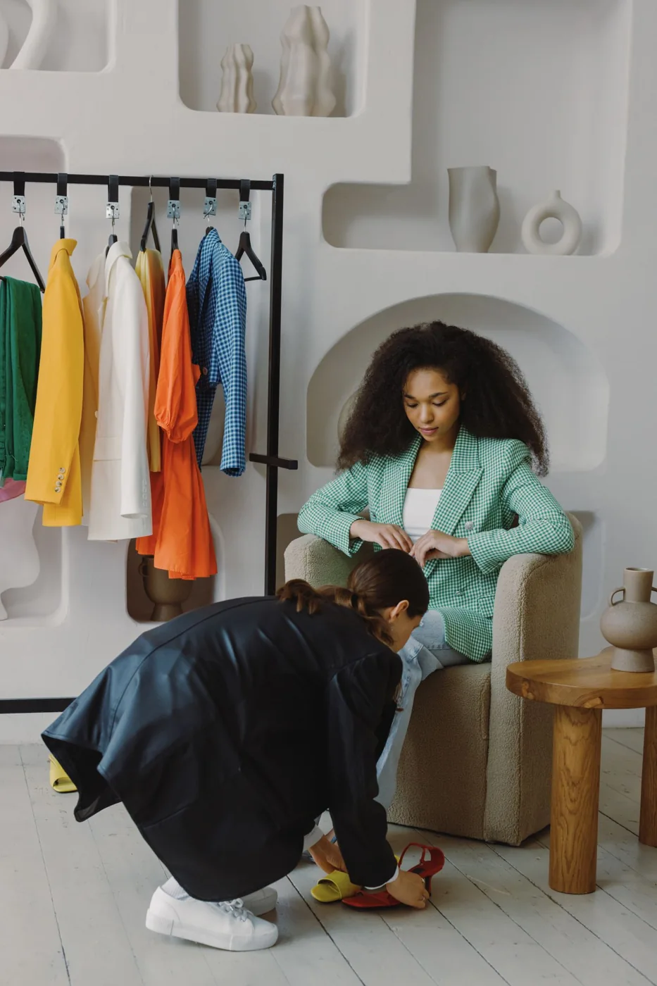 Two women trying on shoes in a clothing boutique