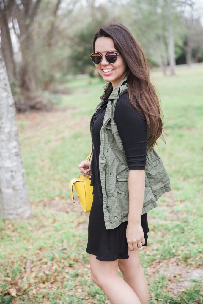 black dress, green vest, yellow purse