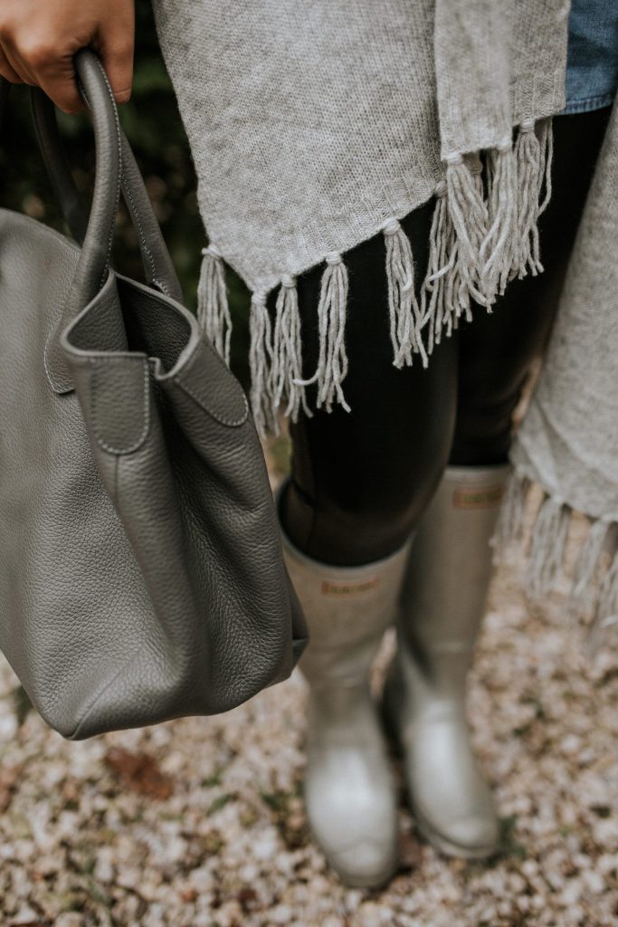 shades of grey in a fringe wrap, top handle purse and metallic silver hunter rain boots