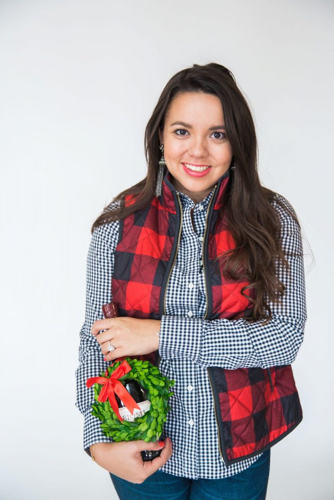 Christmas ready this season with a bottle of wine and a buffalo check vest
