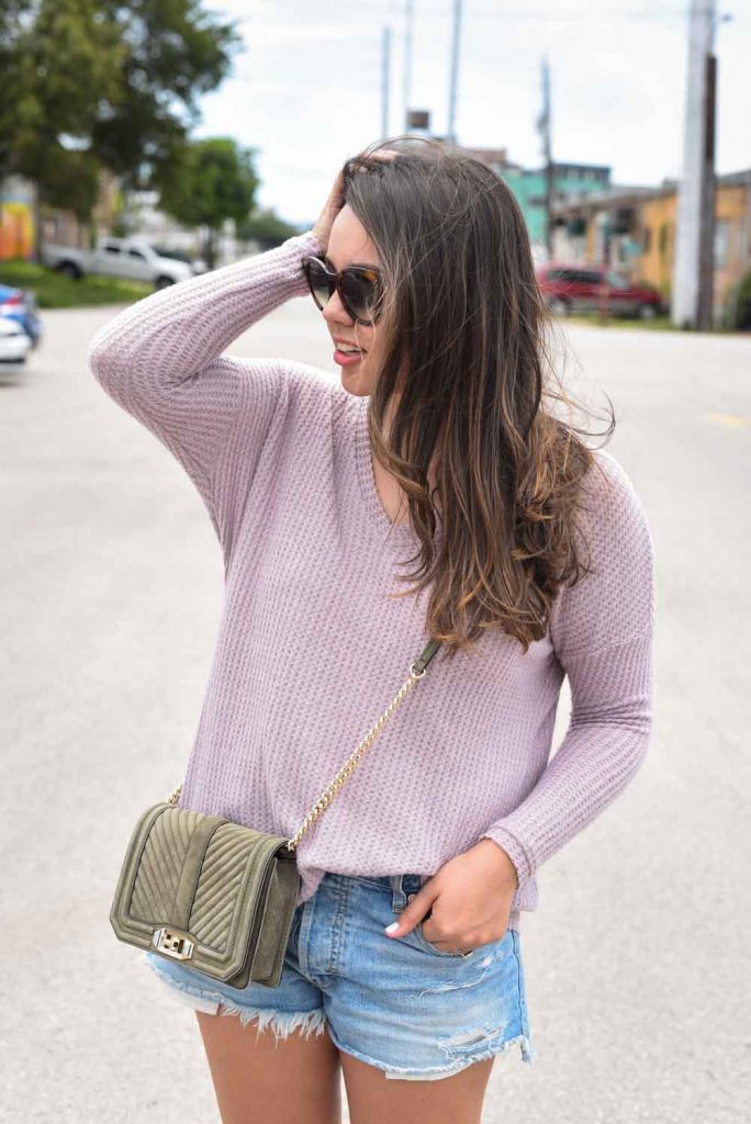 Lilac pullover, denim cut-off shorts, crossbody purse
